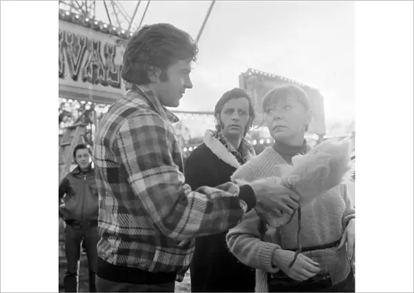 Jim MacLaine hands a soft toy at the funfair