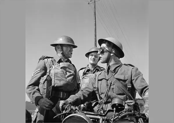 Corporal Bins (John Mills) asks information to another British soldier on a motorbike