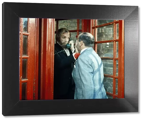 Fred Midway tries to enter a phone box
