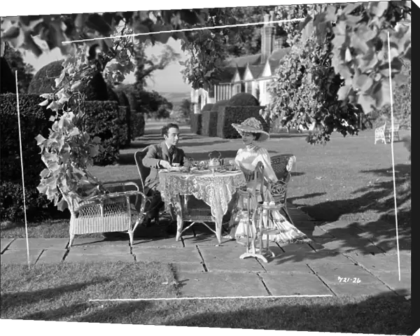 Edith, played by Valerie Hobson and Louis, played by Dennis Price take tea in the garden