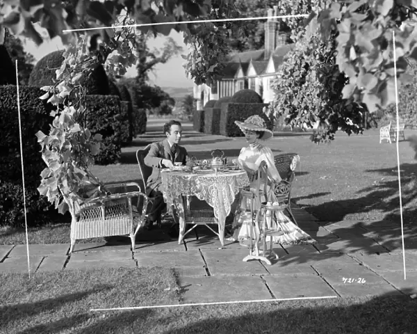 Edith, played by Valerie Hobson and Louis, played by Dennis Price take tea in the garden