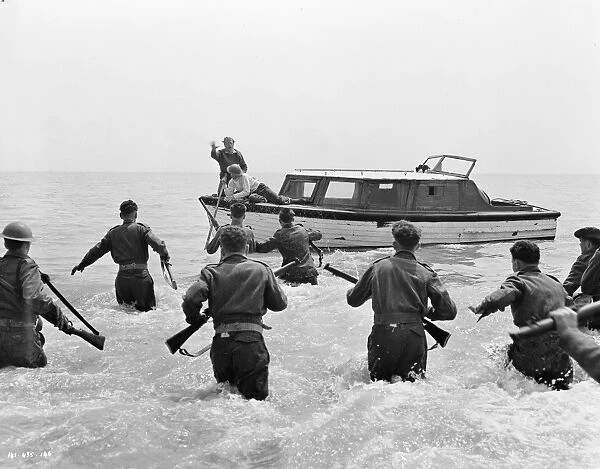 British soldiers run towards the boat of John Holden (Richard Attenborough)