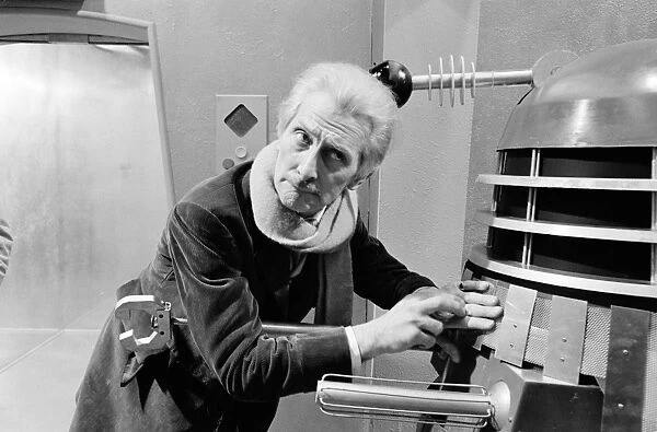 Checking on a Dalek. eter Cushing as Dr Who in a humorous pose taken for