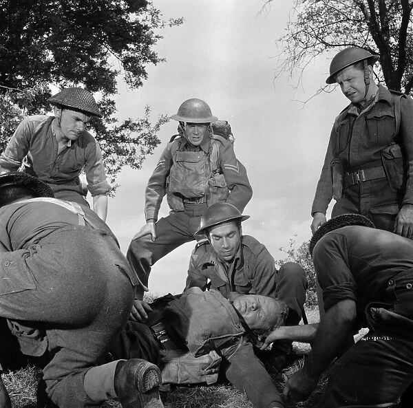 Corporal Bins men. help a wounded soldier in a scene from Dunkirk (1958)