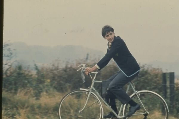 David Essex rides a bicycle