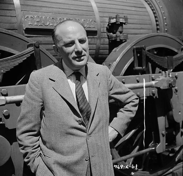 Sir Michael Balcon. in front of the Lion steam engine on location for the