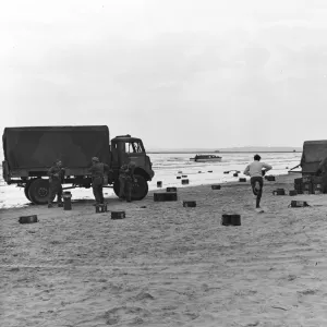 Two British Army trucks stranded on the beach