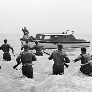 British soldiers run towards the boat of John Holden (Richard Attenborough)