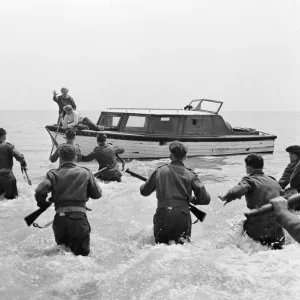 British soldiers run towards the boat of John Holden (Richard Attenborough)