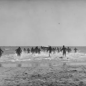 British soldiers run towards the small boats