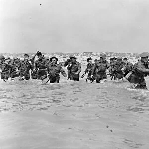 British soldiers run towards the small boats