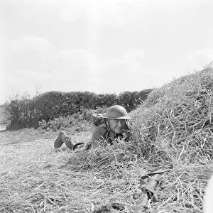 Corporal Tubby Bins hides behind a hay bale