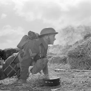 Corporal Tubby Bins hides behind a hay bale