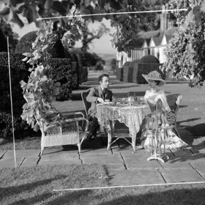 Edith, played by Valerie Hobson and Louis, played by Dennis Price take tea in the garden