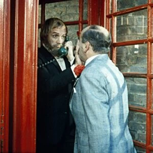 Fred Midway tries to enter a phone box
