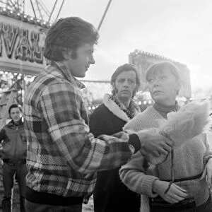 Jim MacLaine hands a soft toy at the funfair