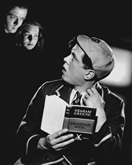 <b class=qtipBold><figcaption>Brighton Rock (1947)</figcaption></b><br>Richard Attenborough dressed as a schoolboy reads a copy of Graham Greene's Brighton Rock.<br><em>© Copyright © Studiocanal Films Ltd</em> Brighton Rock (1947)