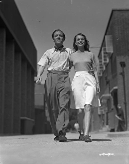 <b class=qtipBold><figcaption>Brighton Rock (1947) publicity</figcaption></b><br>Richard Attenborough and Carol Marsh smiles to the camera in a shot taken outside the stages at Welwyn Studios.<br><em>© Copyright © Studiocanal Films Ltd</em> Brighton Rock (1947) publicity
