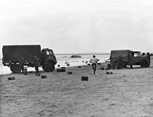 Bombardment Prints: Two British Army trucks stranded on the beach