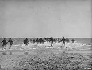British soldiers run towards the small boats