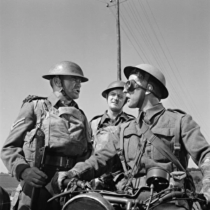 Corporal Bins (John Mills) asks information to another British soldier on a motorbike