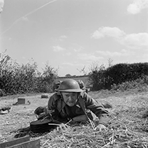 Corporal Tubby Bins hides behind a hay bale