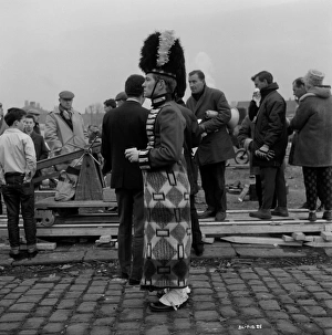 <b class=qtipBold><figcaption>Filming Billy Liar (1963)</figcaption></b><br>A uniformed Tom Courtenay warms himself up wrapped in a blanket during a pause of the filming of Billy Liar in 1963<br><em>© Copyright © Studiocanal Films Ltd</em> Filming Billy Liar (1963)